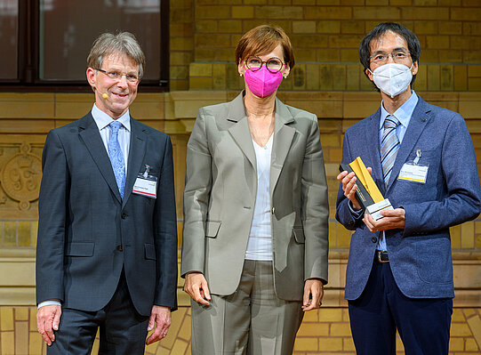 Kou Murayama mit Bundesforschungsministerin Bettina Stark-Watzinger und Präsident der Humboldt-Stiftung, Hans-Christian Pape
