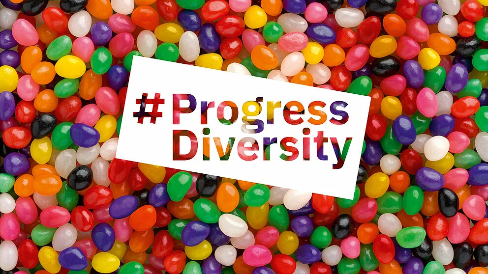 Bunte Jelly Beans im Hintergrund mit der Aufschrift "#Progress Diversity"