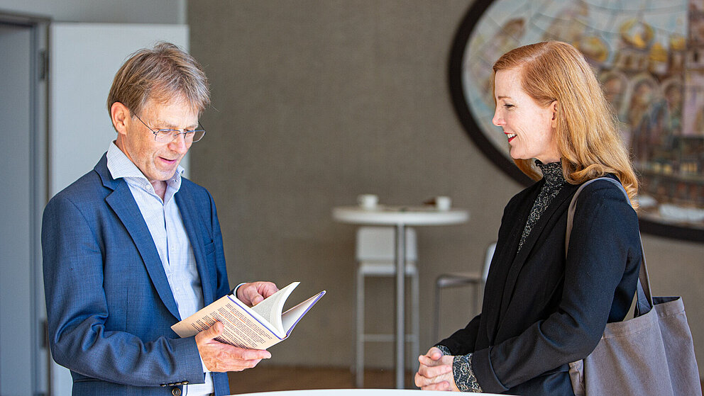 Kate Crawford überreicht Stiftungspräsident Hans-Christian Pape ihr Buch "Atlas of AI"