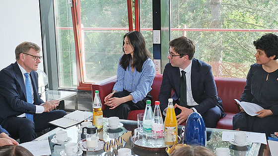 Johann Wadephul sitzt an einem Tisch mit Geförderten von Humboldt-Stiftung und DAAD