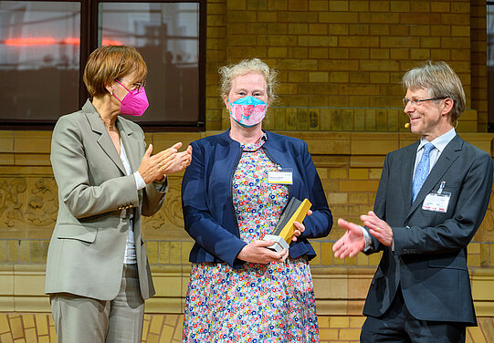 Catherina Becker mit Bundesforschungsministerin Bettina Stark-Watzinger und Hans-Christian Pape, Präsident der Humboldt-Stiftung