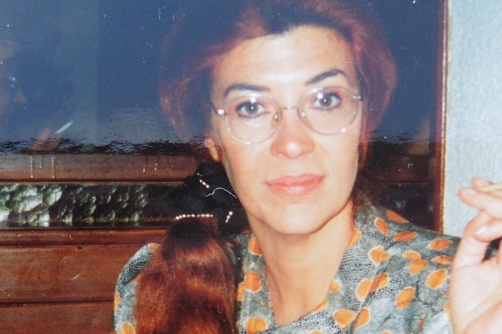 Eine Frau mit Brille in geblümter Satinbluse