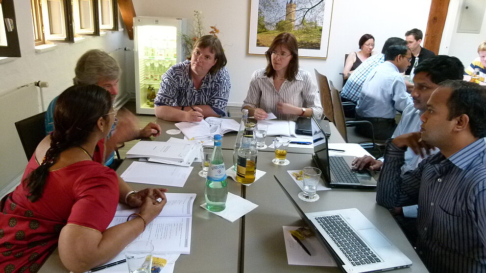 6 Personen sitzen an einem Tisch, arbeiten gemeinsam und unterhalten sich. (Indo-German Frontiers of Engineering Symposium 2014)