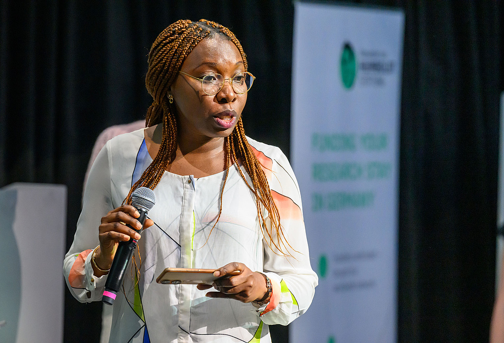 Eine Frau hält ein Mikrofon und ein Smartphone