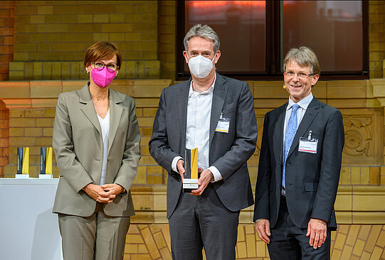 Daniel Rückert mit Bundesforschungsministerin Bettina Stark-Watzinger und Präsident der Humboldt-Stiftung, Hans-Christian Pape