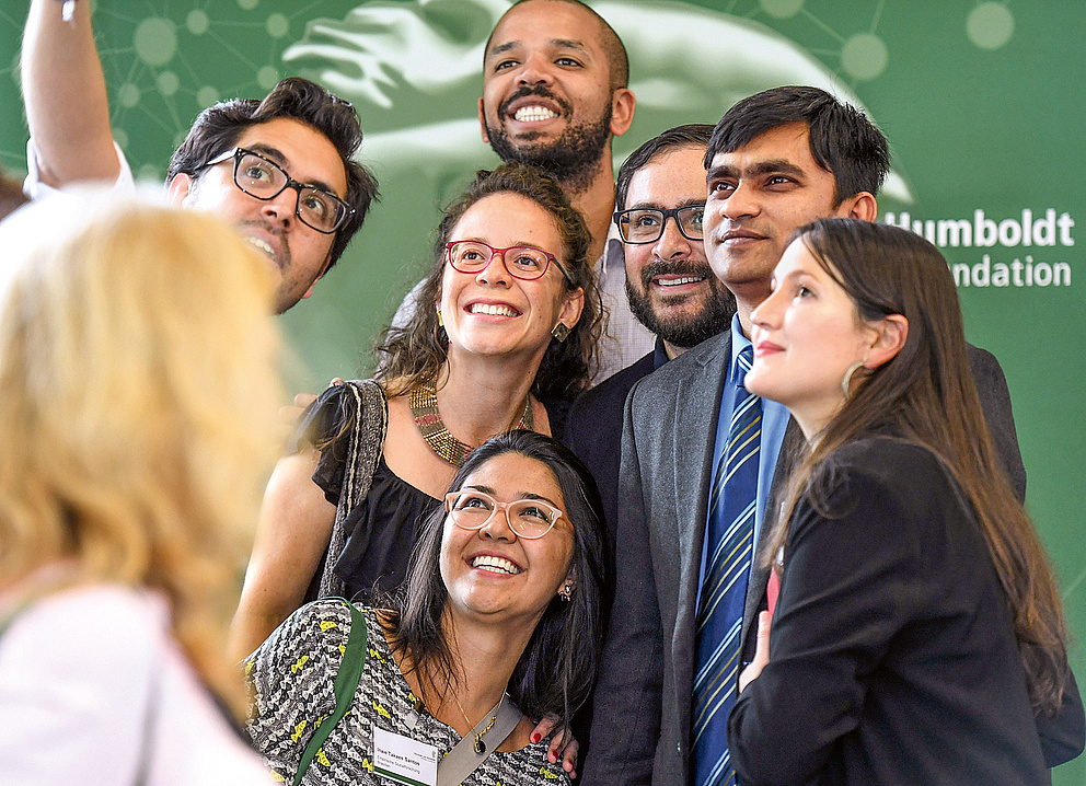 Eine internationale Gruppe von Humboldt-Stipendiat*innen nimmt ein Gruppenselfie auf einer Veranstaltung der Stiftung auf.