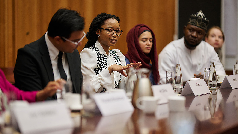 Five people with name tags at a table in a round table discussion