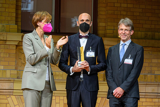 Christian Frezza mit Bundesforschungsministerin Bettina Stark-Watzinger und Hans-Christian Pape, Präsident der Humboldt-Stiftung