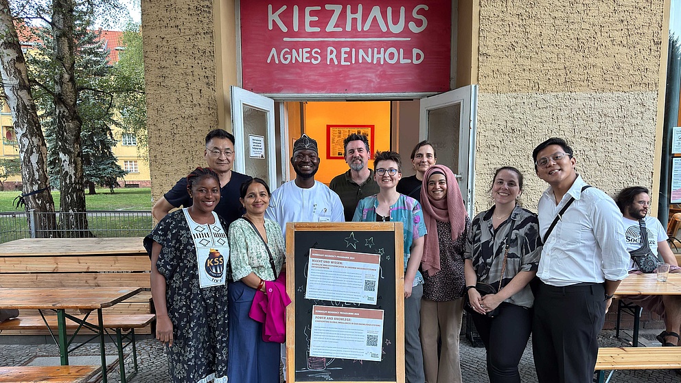 Eine Gruppe von Menschen vor dem Eingang eines Hauses