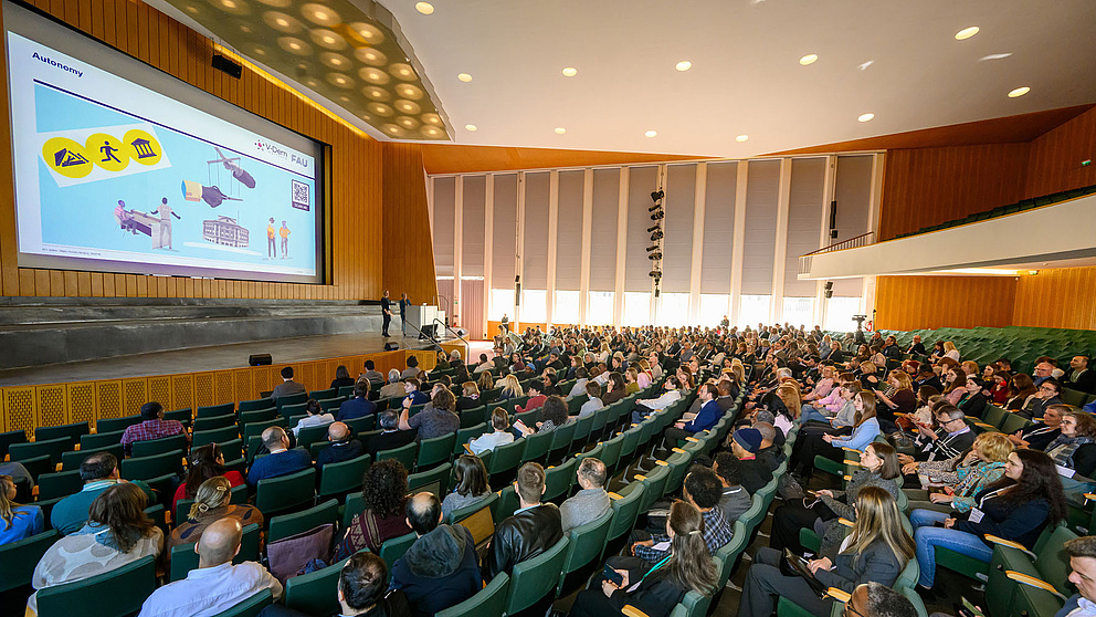 Weitwinkelaufnahme vom gefüllten Hörsaal der FU Berlin.