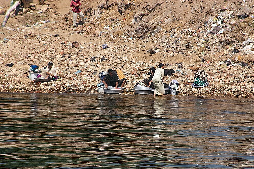 Menschen waschen Utensilien am Nil