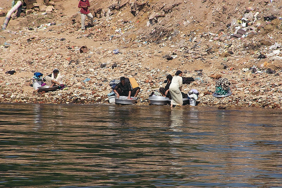 Menschen waschen Utensilien am Nil