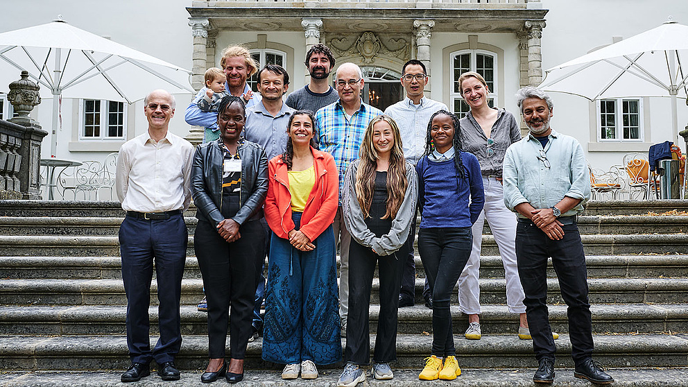 Gruppenfoto auf einer Steintreppe vor dem Eingang eines großen weißen Gebäudes