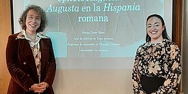 Henriette Herz-Scout Sabine Panzram und Humboldt-Stipendiatin Noelia Cases Mora stehen gemeinsam vor einer Vortrags-Projektion