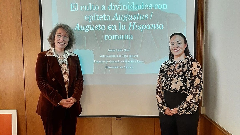 Henriette Herz-Scout Sabine Panzram und Humboldt-Stipendiatin Noelia Cases Mora stehen gemeinsam vor einer Vortrags-Projektion