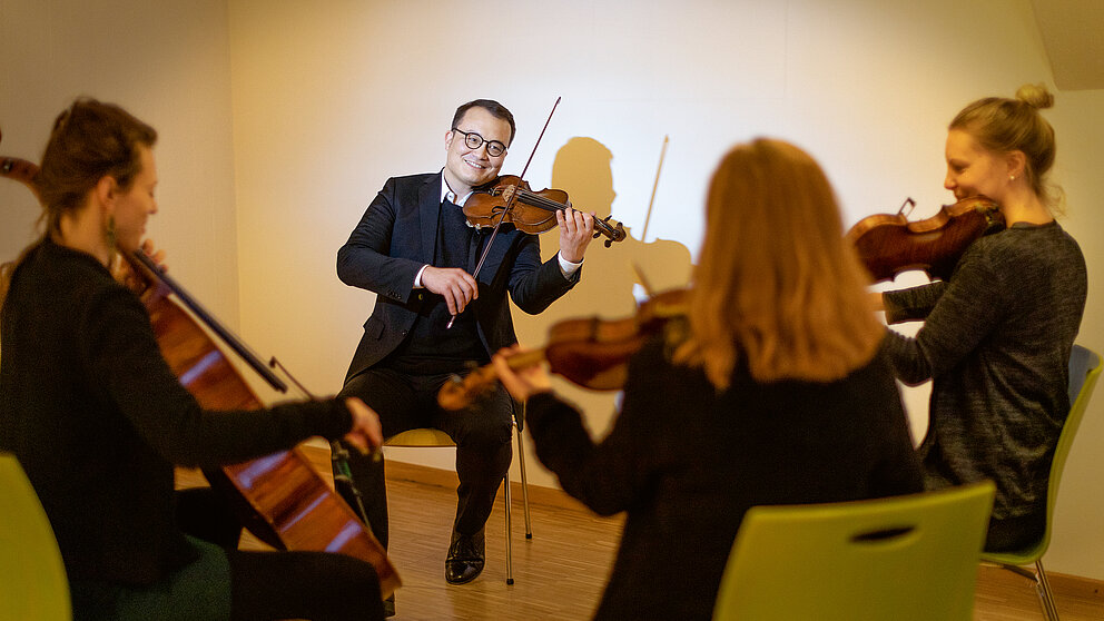Frank Albrecht mit seiner Geige und drei weitere Musiker*innen spielen gemeinsam als Streichquartett.