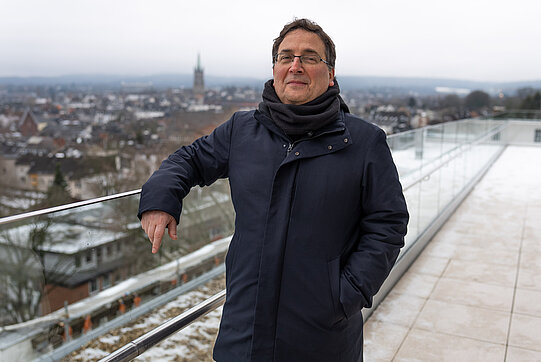 Foto von Hector Geffner auf einer Dachterrasse mit einer Stadt im Hintergrund