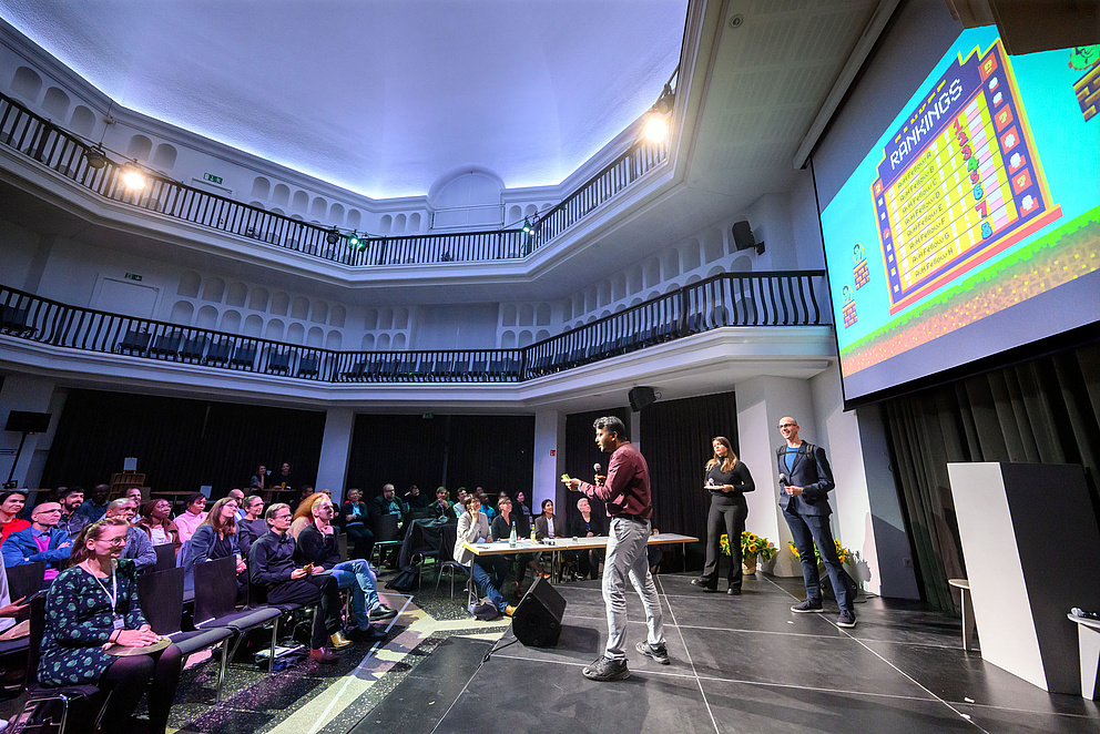 Ein Mann steht auf einem Podium und spricht zu einem Publikum