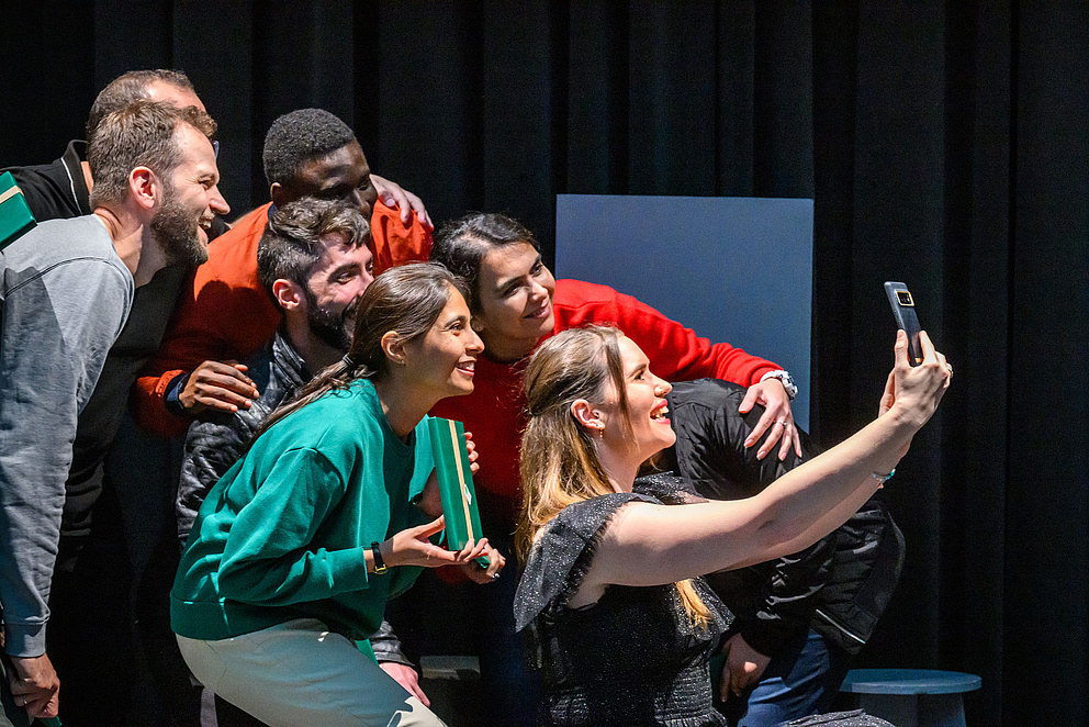 Sieben Menschen, die lächelnd ein Selfie machen