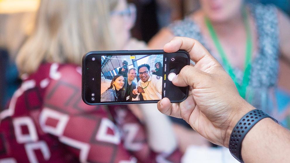 Eine Hand hält ein Handy für ein Selfie