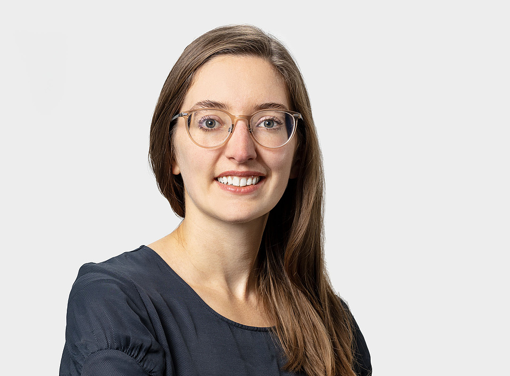 Portrait photo of Elisa Ronzheimer, a woman with long dark hair and glasses
