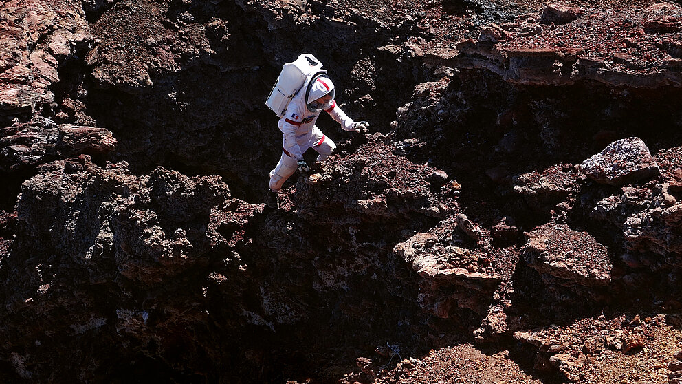 Astronaut in einer Vulkanlandschaft 