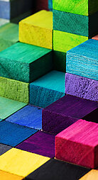 Spectrum of stacked multi-colored wooden blocks. Background or cover for something creative, diverse, expanding,  rising or growing.