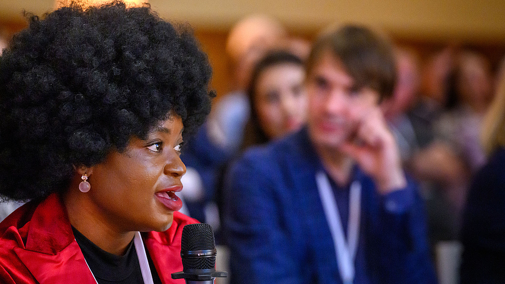 Adenike Akinsemolu spricht ins Mikrofon