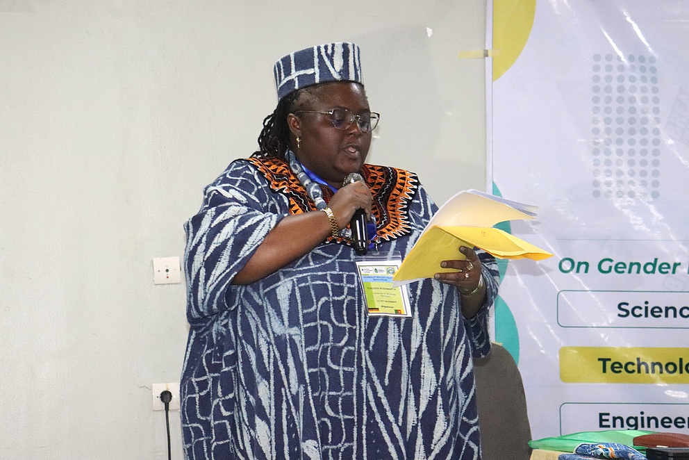 Das Bild zeigt Rosemary Tonjock mit einem Mikrofon in der Hand, wie sie beim Humboldt-Kolleg in Bafoussam spricht.