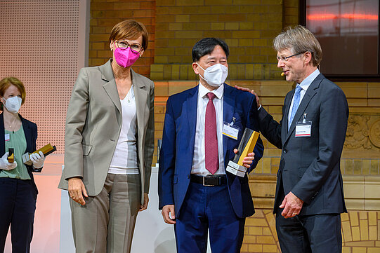 Yaochu Jin mit Bundesforschungsministerin Bettina Stark-Watzinger und Hans-Christian Pape, Präsident der Humboldt-Stiftung