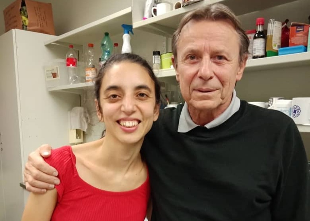 Das Foto zeigt Paula Tribelli Arm in Arm mit Friedrich Götz an der Universität Tübingen. Beide lächeln; sie trägt ein rotes T-Shirt und er einen schwarzen Pullover über einem hellblauen Hemd.