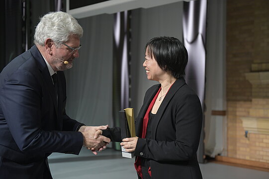 Stiftungspräsident Robert Schlögl schüttelt die Hand von Angela Yu