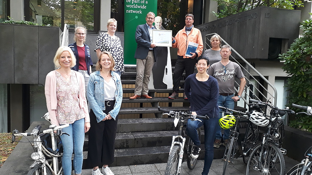 Beschäftigte der Stiftung stehen mit ihren Fahrrädern und Generalsekretär Hesse und ADFC-Auditor vor dem Gebäude der Stiftung