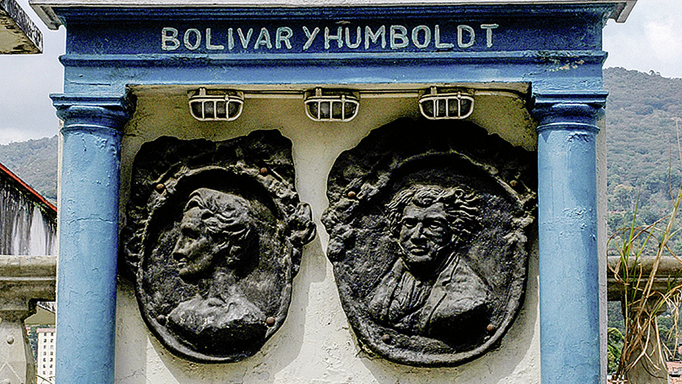 Denkmal mit blauen Säulen, zwei Köpfen in Steinreliefs und der Aufschrift "Bolivar y Humboldt"